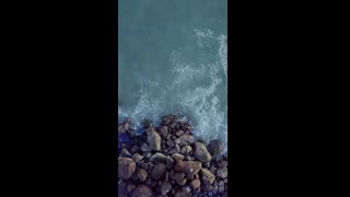 mixkit-overhead-view-of-a-rocky-coast-and-waves-crashing-51502-hd-ready